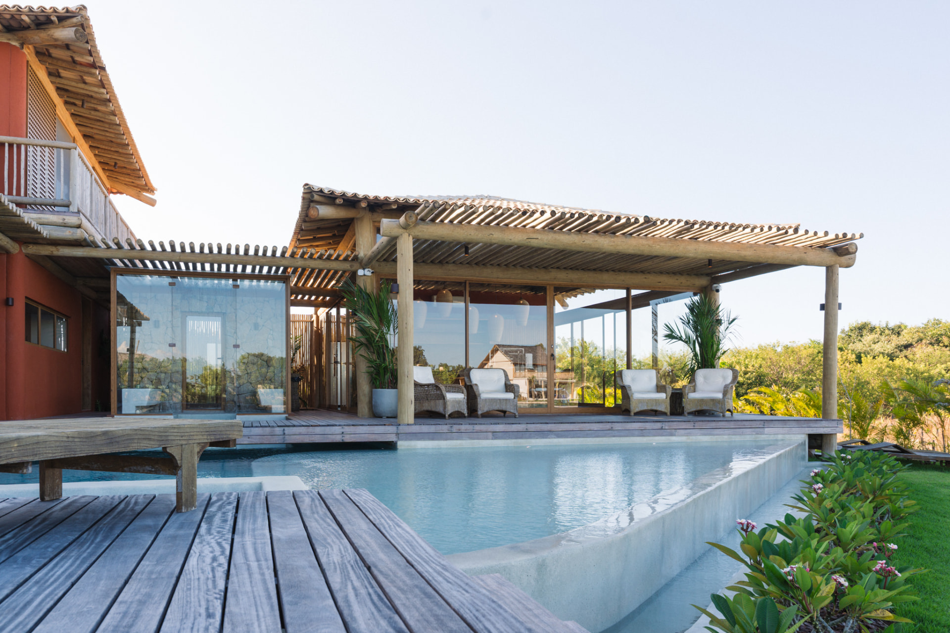 Piscina com deck de madeira e varanda coberta
