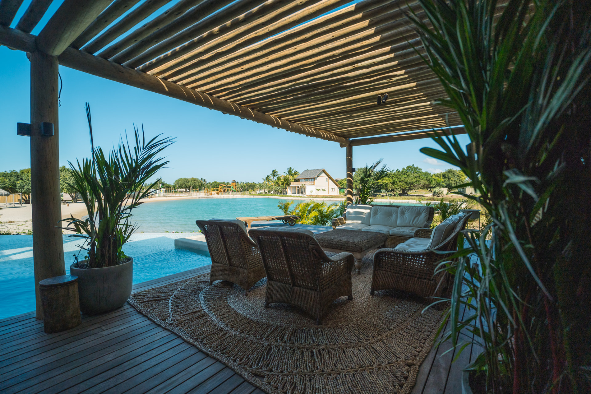 Estar externo coberto à beira da piscina