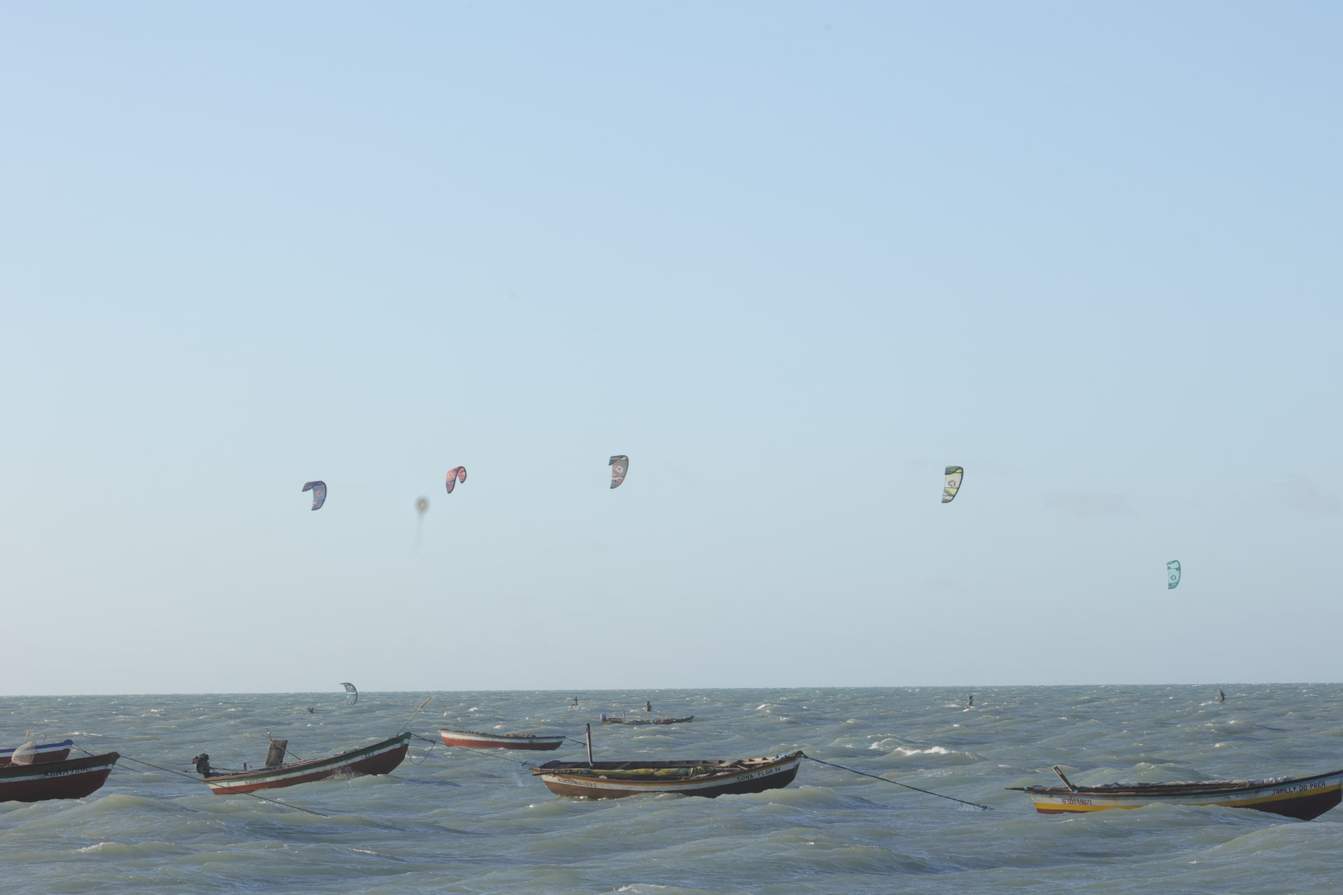 Barcos de pesca e kites no mar do Preá
