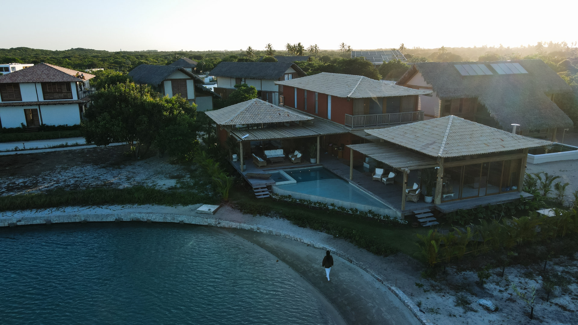 Vista aérea da Casa Doca com piscina e a lagoa ao entardecer
